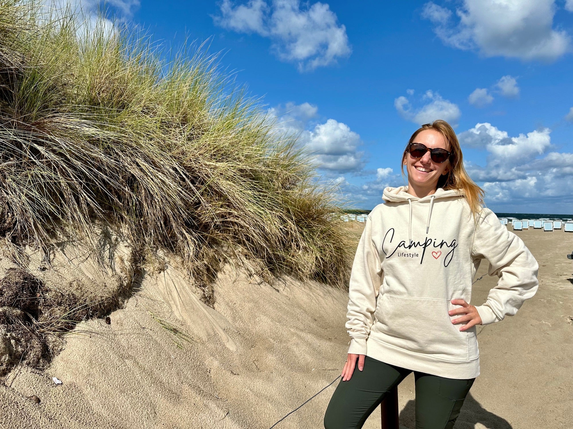 Frau mit Camping Hoodie vor der Düne